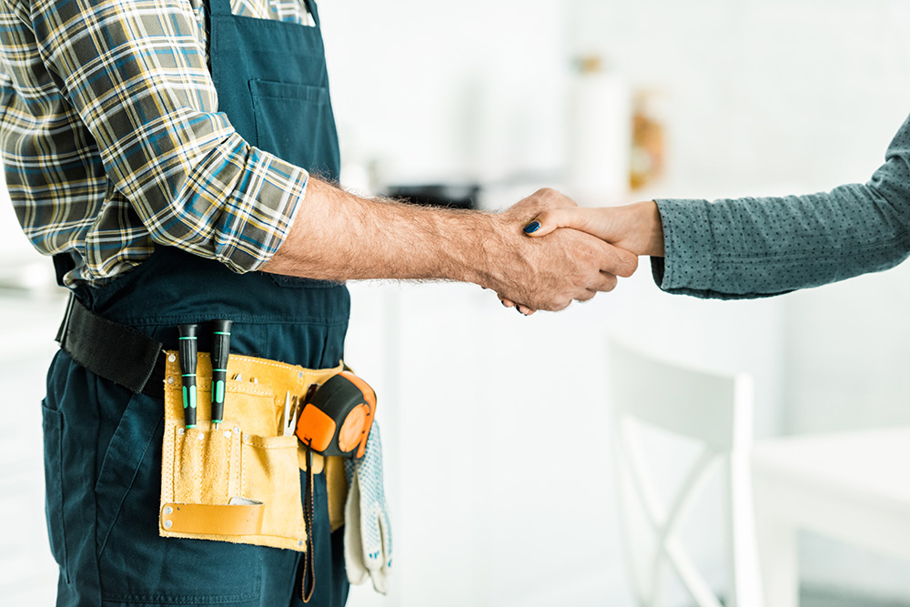 Handyman shaking hands with a homeowner