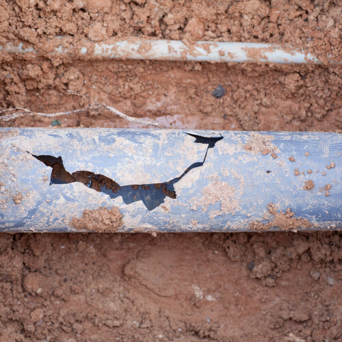 A broken sewer drain in the dirt