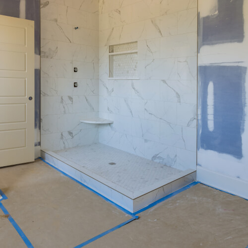 A new shower without plumbing, in a bathroom with construction paper taped to the floor